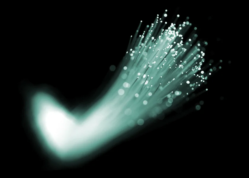 Glasfasernetz Vorteile, abstrahiertes Foto eines weiß-türkis leuchtenden, fächerförmig auseinanderlaufenden Glasfaserbündels auf schwarzem Grund – steht für 1000 Mbit/s Highspeed-Internet und zukunftssichere Konnektivität.